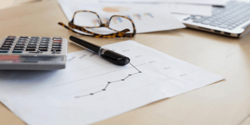 eyeglasses, pen and paper, symbolizing Retirement Planning